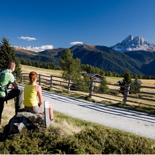 Zwei Wanderer genießen die Aussicht von einer Alm