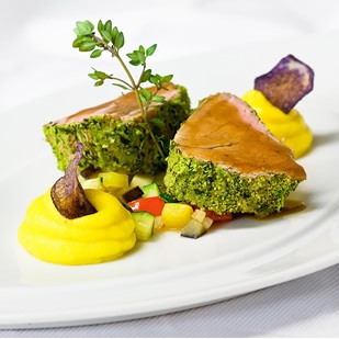 Carne tenera in crosta d’erbe con purè, dadolata di verdure e chips viola decorativa.