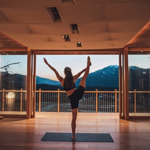 A woman is doing yoga in the yoga room