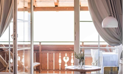 Bright room with view of wooden balcony