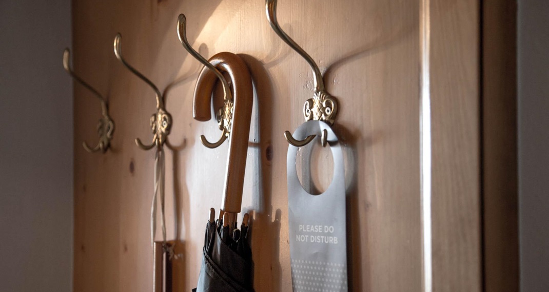 Wooden coat rack with umbrella and “Do not disturb” sign