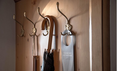 Wooden coat rack with umbrella and “Do not disturb” sign