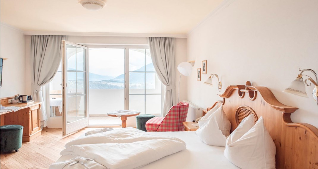 Camera doppia Rosa Alpina con letto matrimoniale, angolo soggiorno e balcone