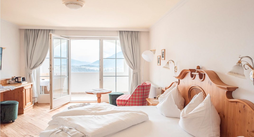 Camera doppia Rosa Alpina con letto matrimoniale, angolo soggiorno e balcone