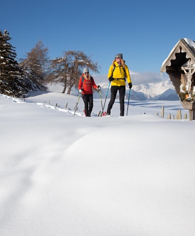 Zwei Frauen machen eine Schneeschuhwanderung auf der Alm