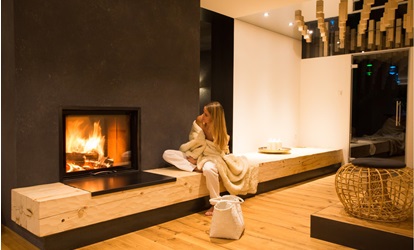 Una donna in un'area relax con un camino acceso