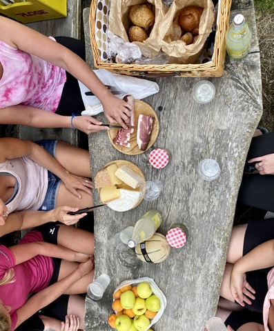 Picnic with bread, cheese, ham, and fruit