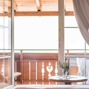 Helles Zimmer mit Blick auf einen Holzbalkon
