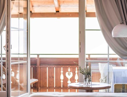 Bright room with view of wooden balcony