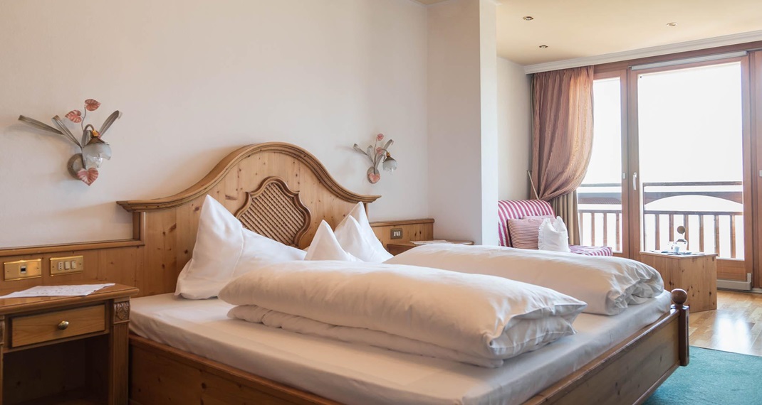 Camera doppia Stanza delle Rose con letto matrimoniale, angolo soggiorno e balcone