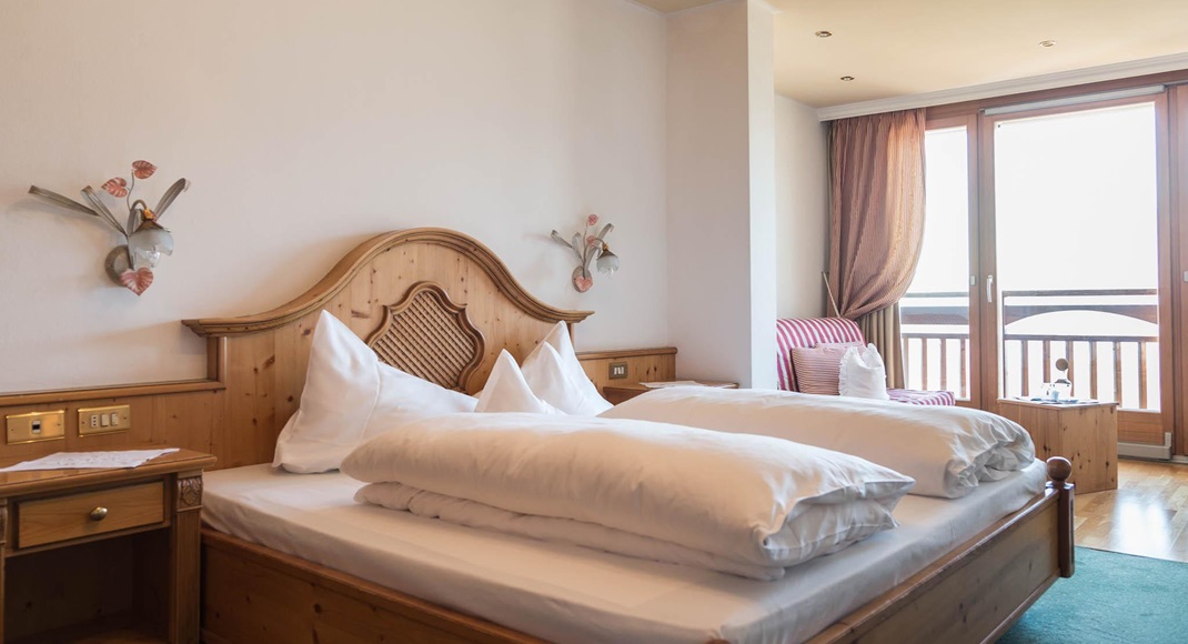 Camera doppia Stanza delle Rose con letto matrimoniale, angolo soggiorno e balcone