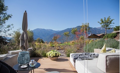 Moderne Terrasse mit Lounge und Bergblick an einem sonnigen Herbsttag.