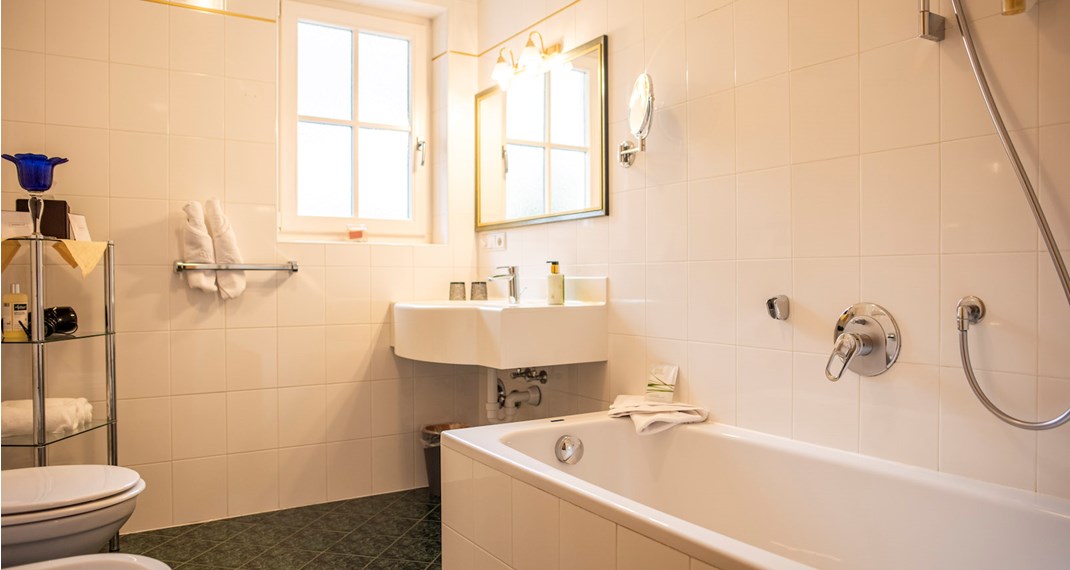 Das Badezimmer mit Waschbecken, WC und Badewanne