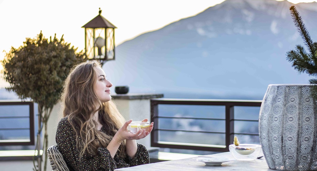 Una donna beve una tazza di tè in terrazza