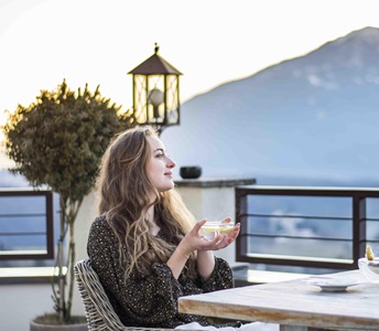 A woman is having a cup of tea on the terrace
