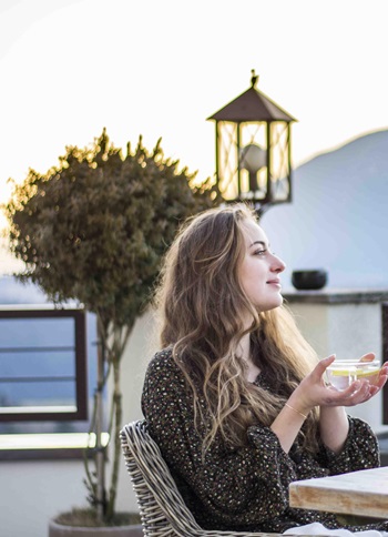 Eine Frau genießt eine Tasse Tee auf der Terrasse