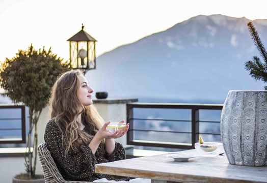 Una donna beve una tazza di tè in terrazza