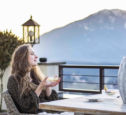 A woman is having a cup of tea on the terrace